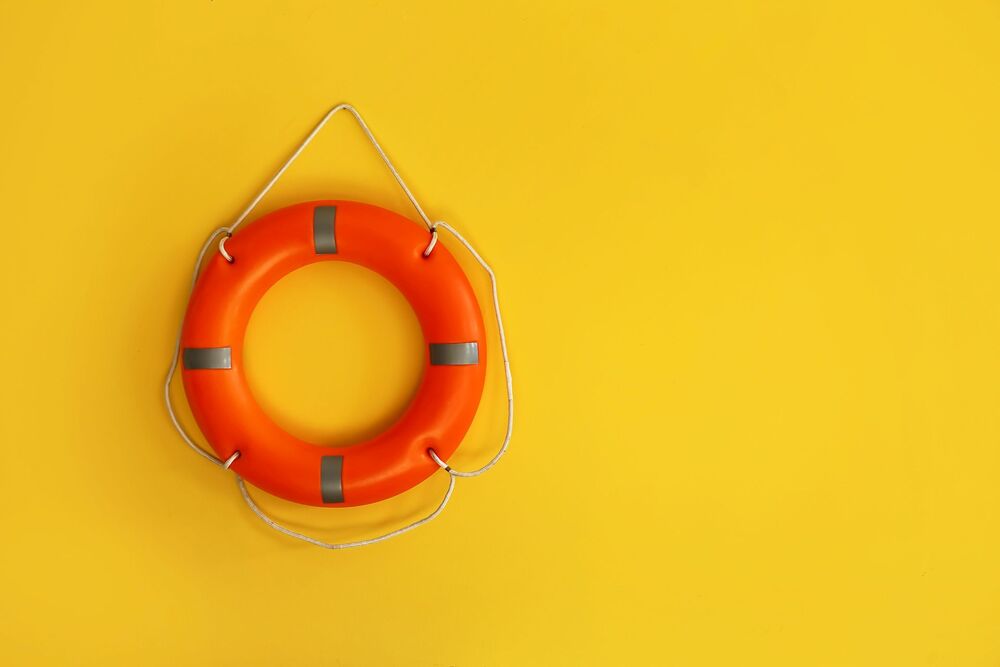 Ring buoy hanging on yellow wall
